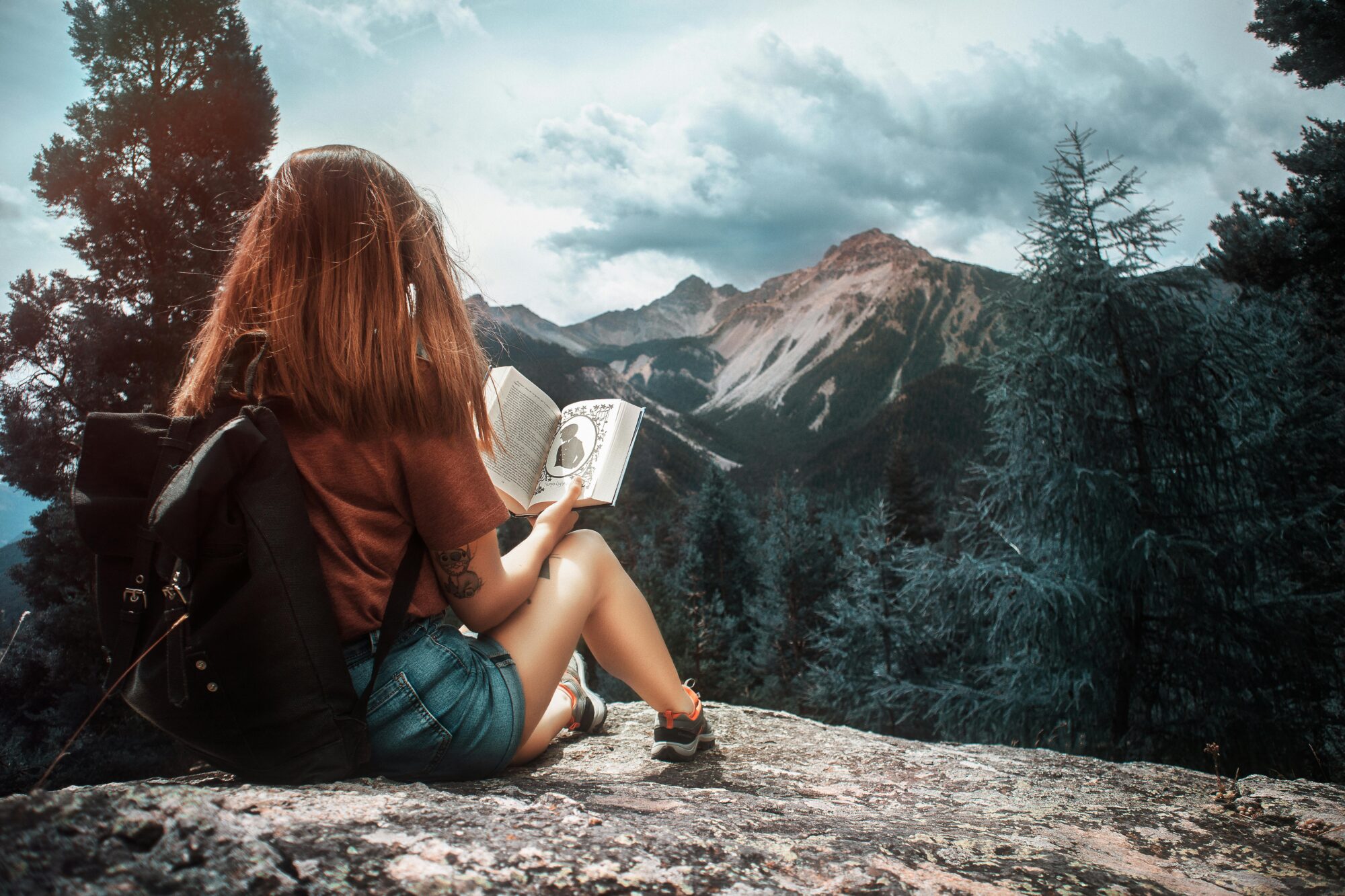 woman reading at top of mountain