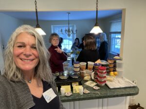 book club members smiling and looking at 16 ounce containers of soup stacked up for the soup swap