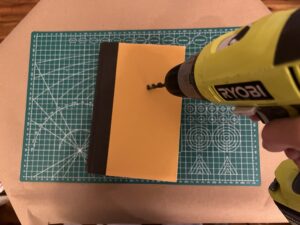 DIY book clock tutorial - drilling the hole in the cover of the book 